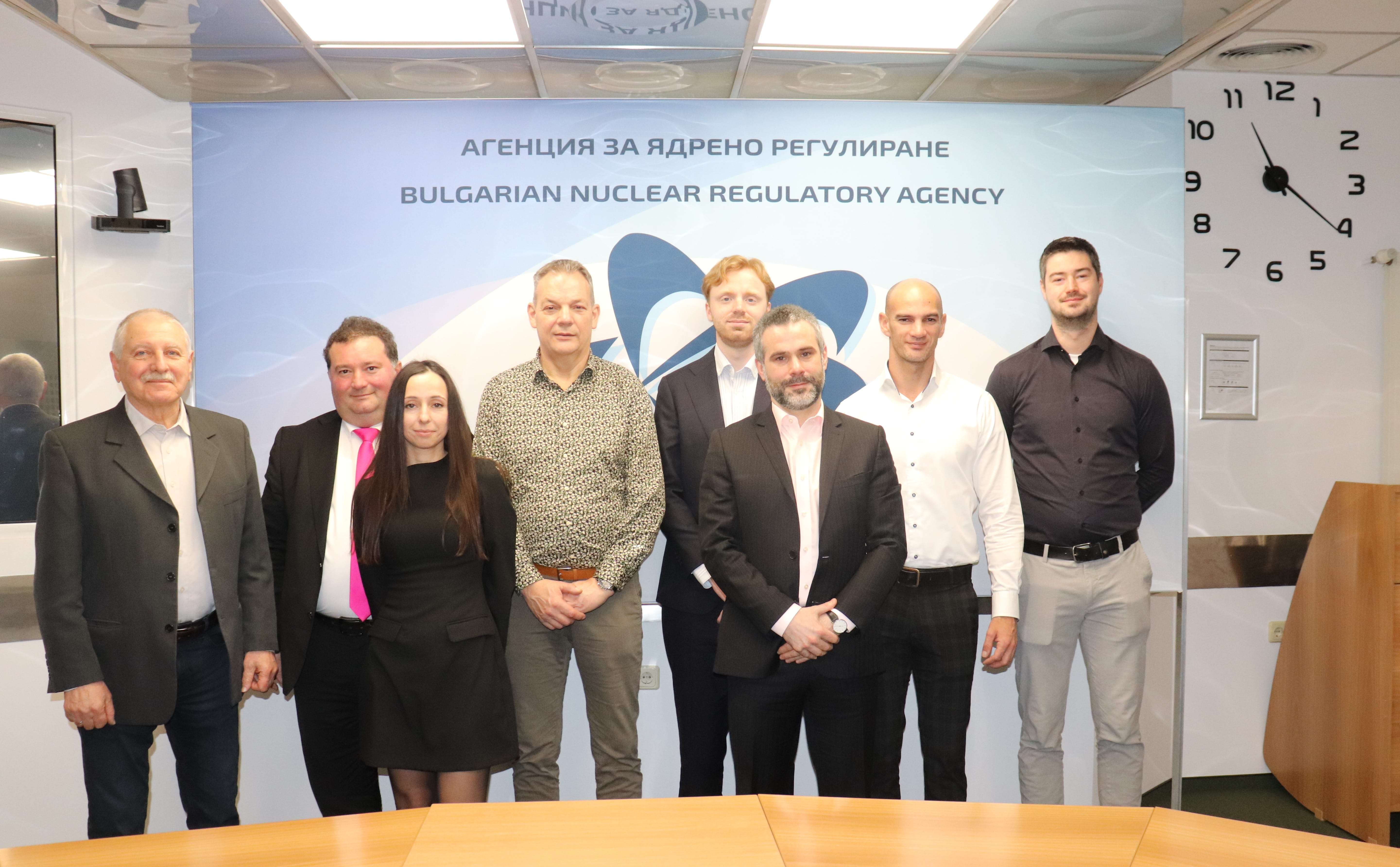 Седем души в редица в офиса на АЯР, официална снимка - ангажираност с ядрена безопасност и радиационна защита.